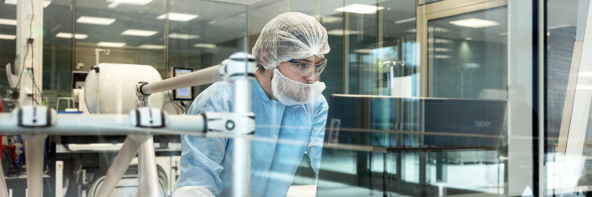 A person in protective clothing typing working on a PC (photo)